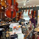Photo by Patricia Guthrie. Aniela Perry stands inside Tiny House of Strings in Freeland, where she teaches, sells, rents and repairs violins. She renovated the 100-year-old cottage when she moved in five years ago.