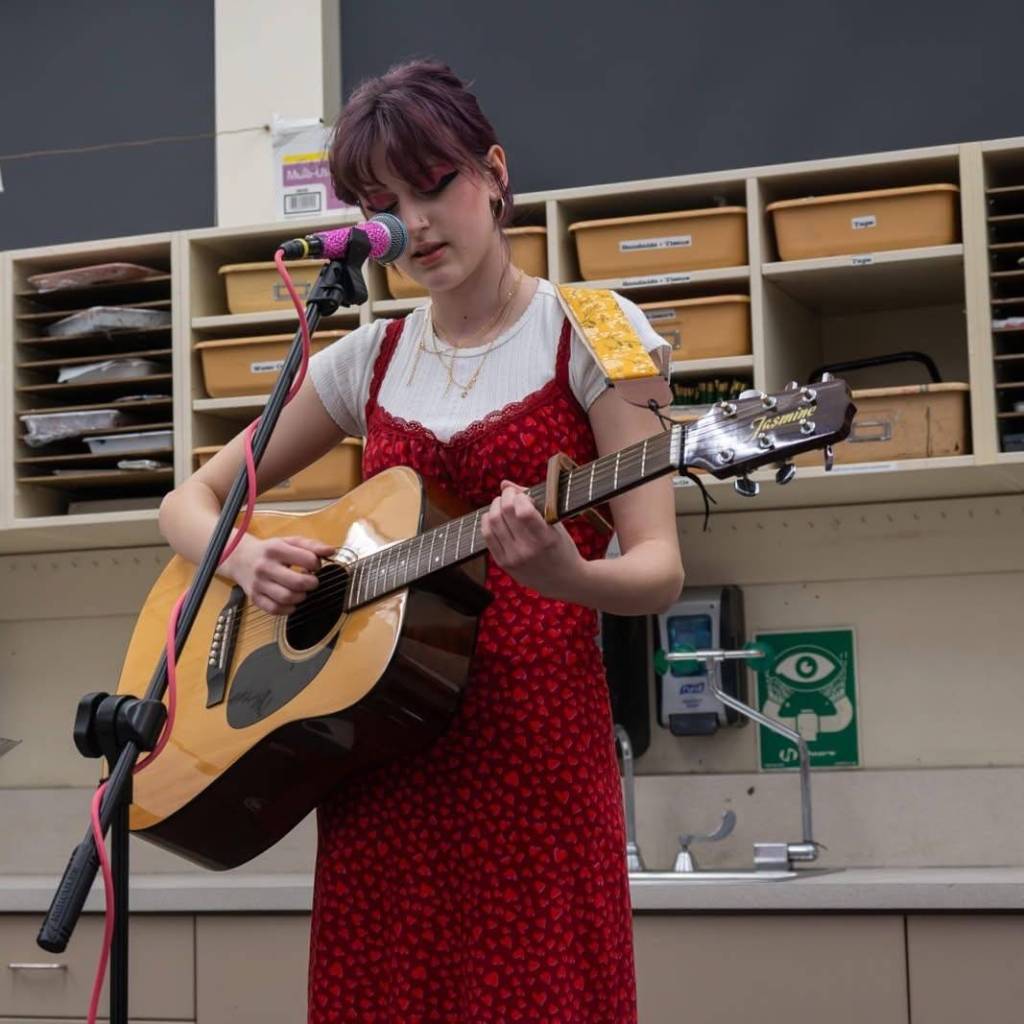 Olive sings at the OHHS Art and literature show in March 2026.