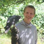 Photo by Marina Blatt. Cole Serad holds a peregrine falcon with a calm poise while educating senior citizens on how easily it could kill them, and other fun facts.